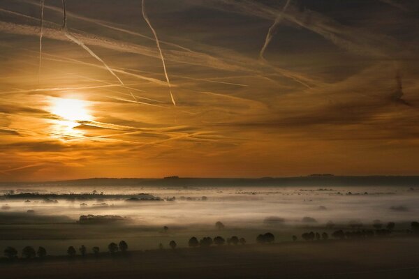 Das Tal ist im Nebel. Sonnenuntergang, Bäume im Feld