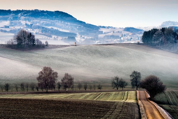 Felder und Hügel Italiens. Landschaften Italiens. Eine Stadt im Nebel