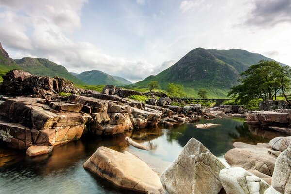 Paisaje de montañas boscosas y ríos rodeados de grandes rocas