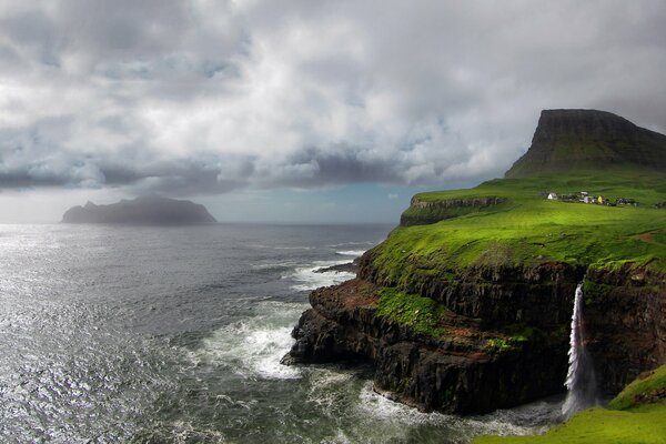 Title a look at the combination of the Atlantic Ocean and a waterfall flowing down from the mountain