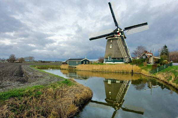 Autumn sky. mill in the canal