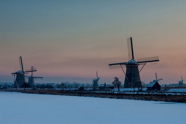 Schneebedeckte Mühlen im Hintergrund des Sonnenuntergangs