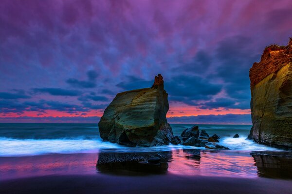 Sunset at the rocks of the Tasman Sea in New Zealand