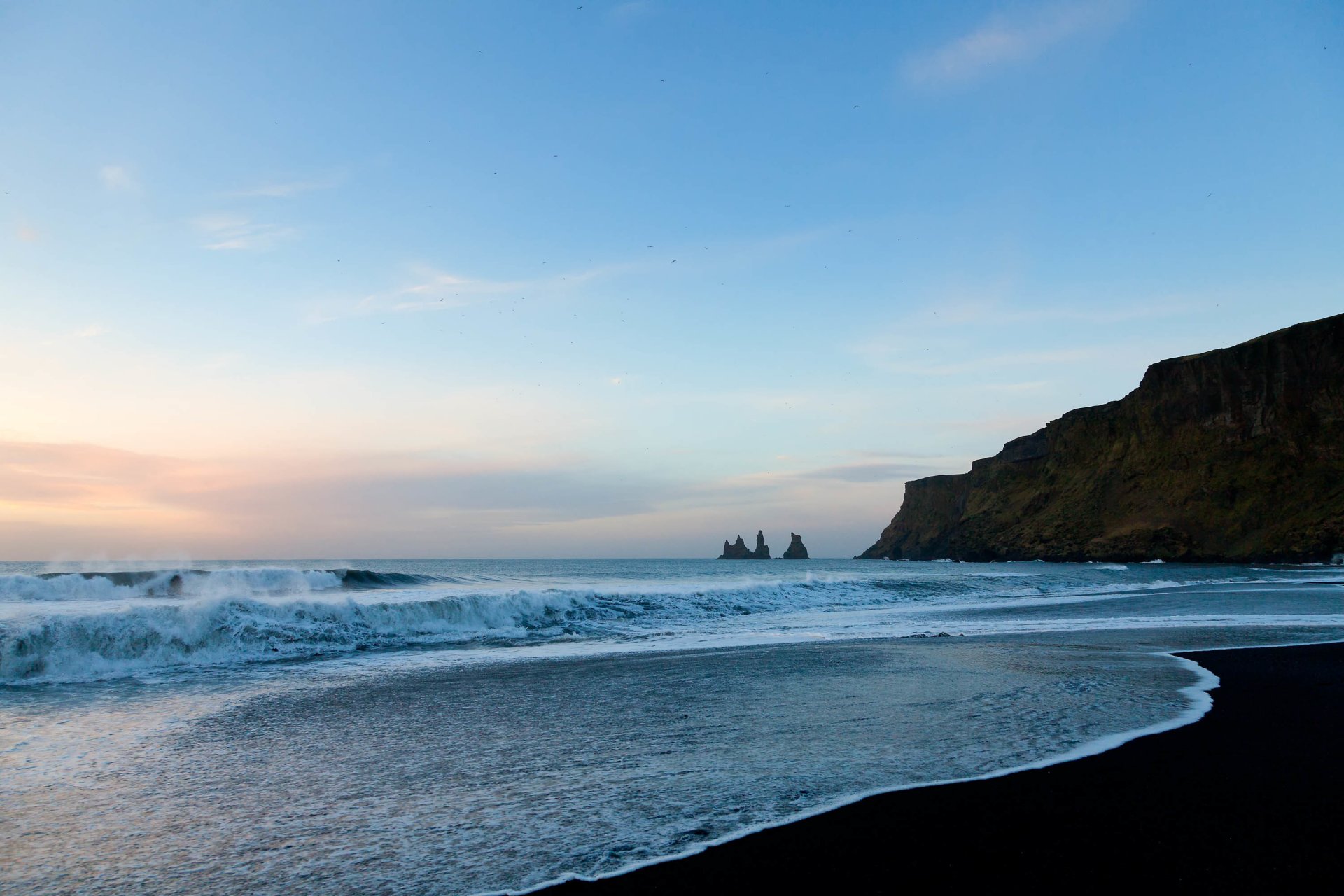 plage sable océan eau vagues mousse roches ciel nuages oiseaux horizon