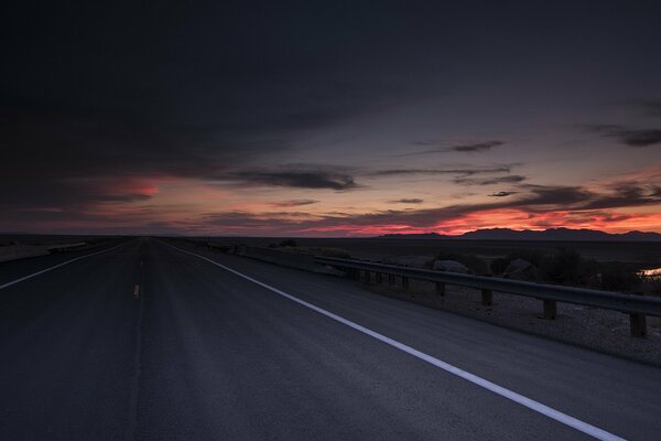 The road on the background of a scarlet sunset