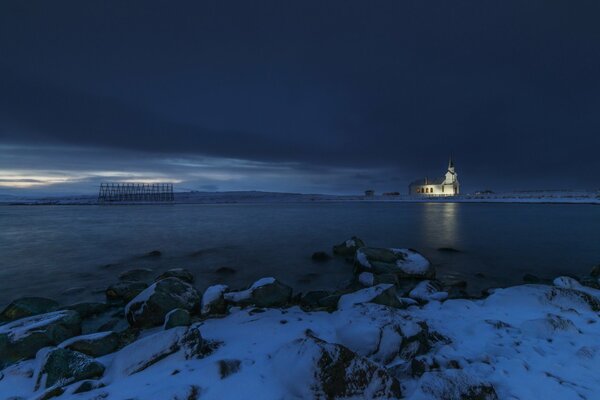 The church stands like a lonely guardian against the background of the winter polar night