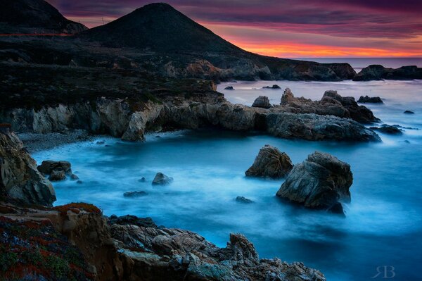 Amanecer en la costa rocosa del mar