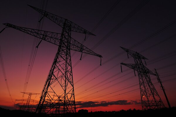 Coucher de soleil rose sur fond de supports de lignes électriques