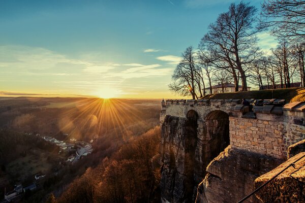 Fortezza sullo sfondo del tramonto e alberi spogli