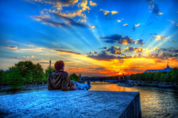 Mann auf einem Stein bei Sonnenuntergang in Paris