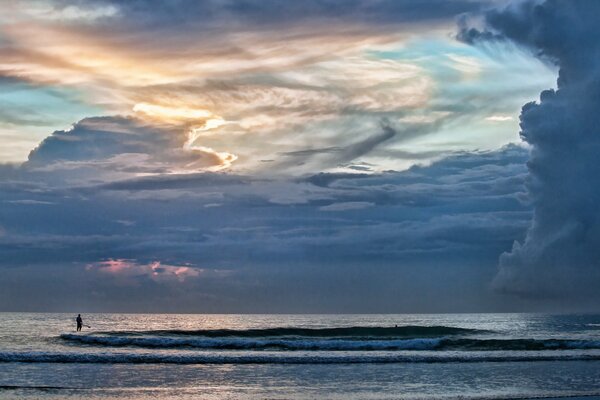 A man by the sea under a huge sky