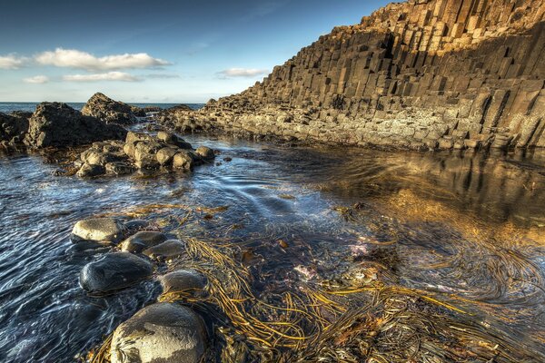 Seashore with clear water on the background of rocks