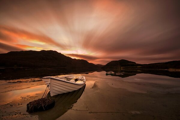 Barca in riva al lago con Tramonto