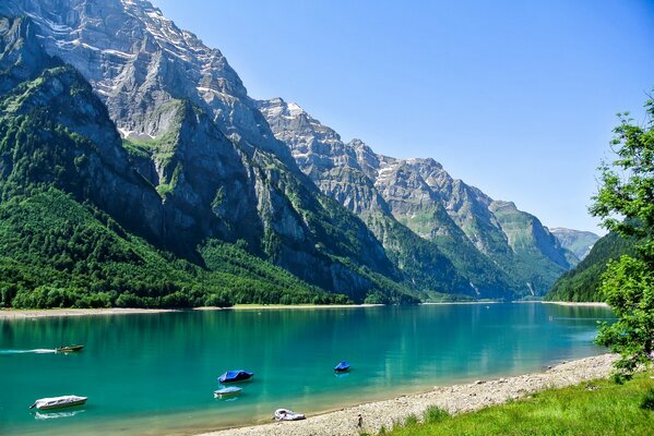 Floating boats on a lake near the mountains of Switzerland