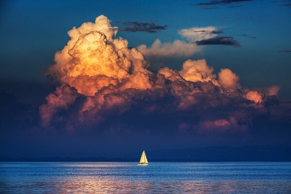 A lonely white sailboat in a dark sea