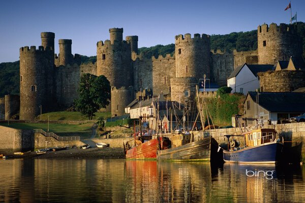 Château avec des bateaux amarrés sur le rivage