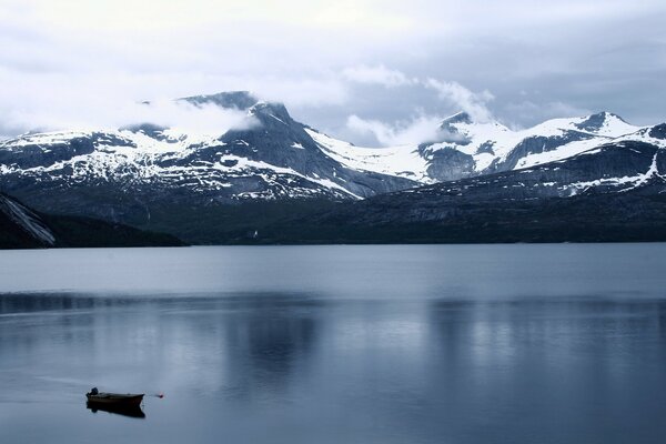 Montañas de invierno y lagos con barco