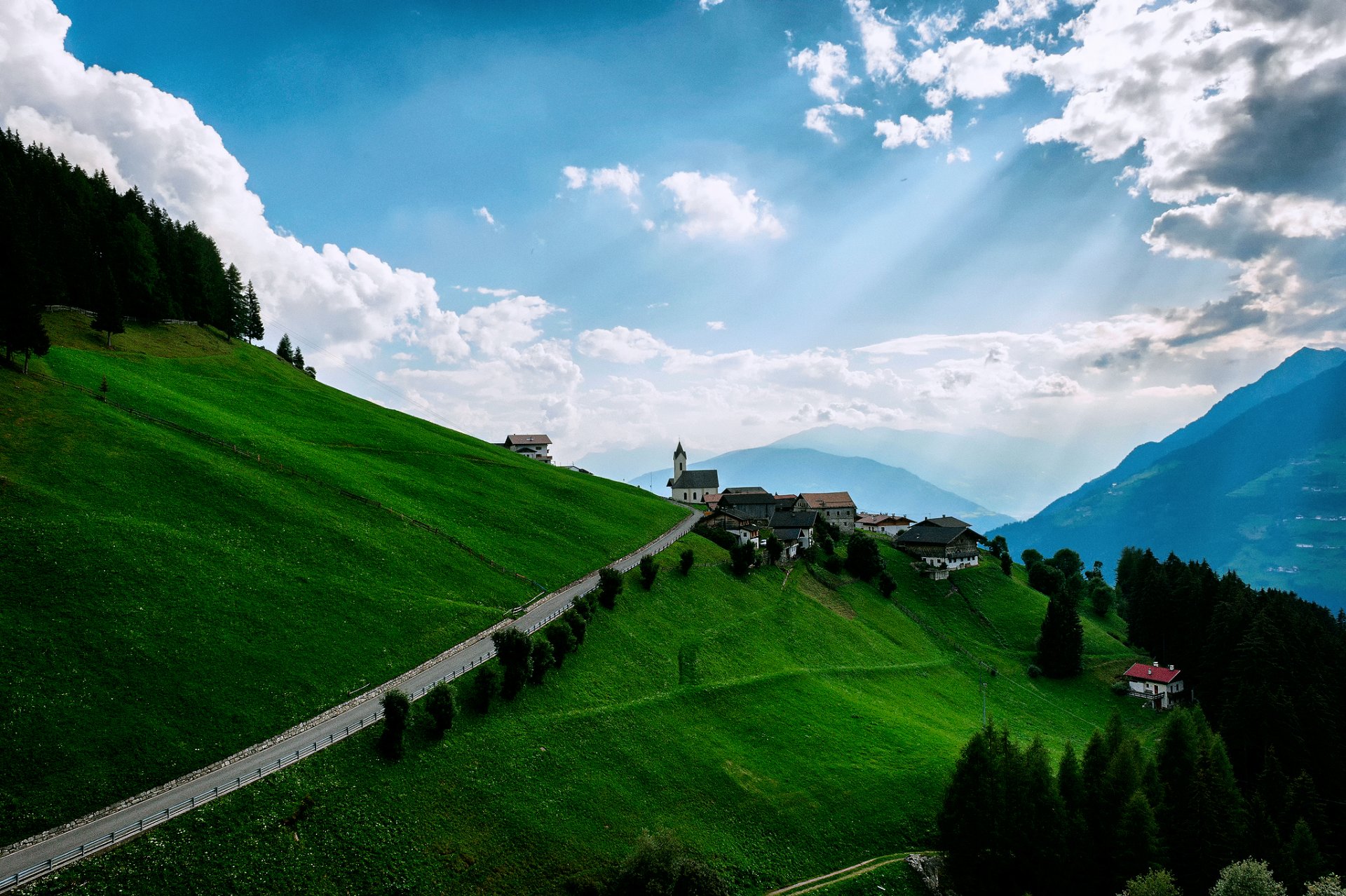 montagne prati pendii case cielo nuvole