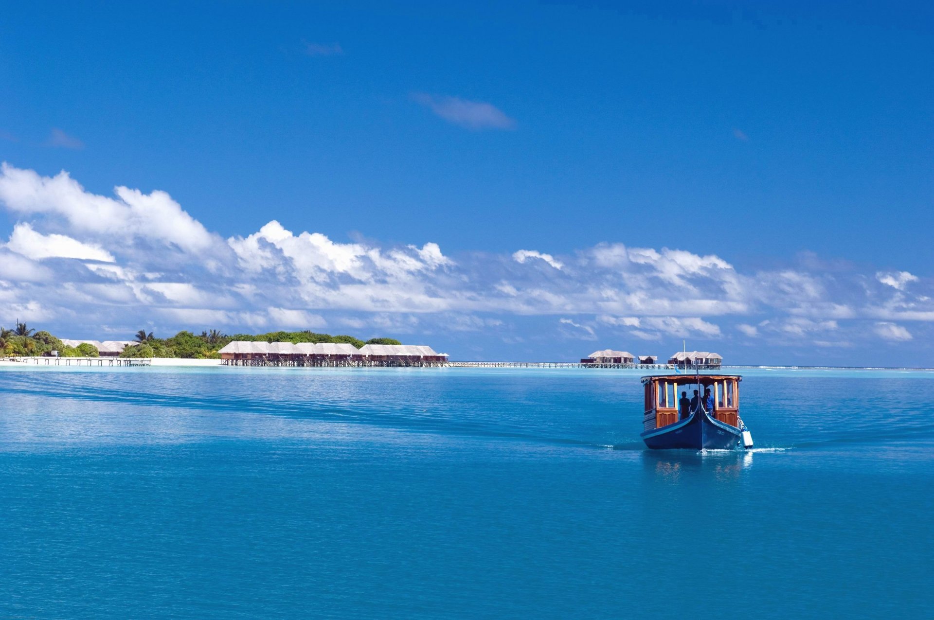 ciel mer océan île maldives bateau bateau palmiers nuages bungalow