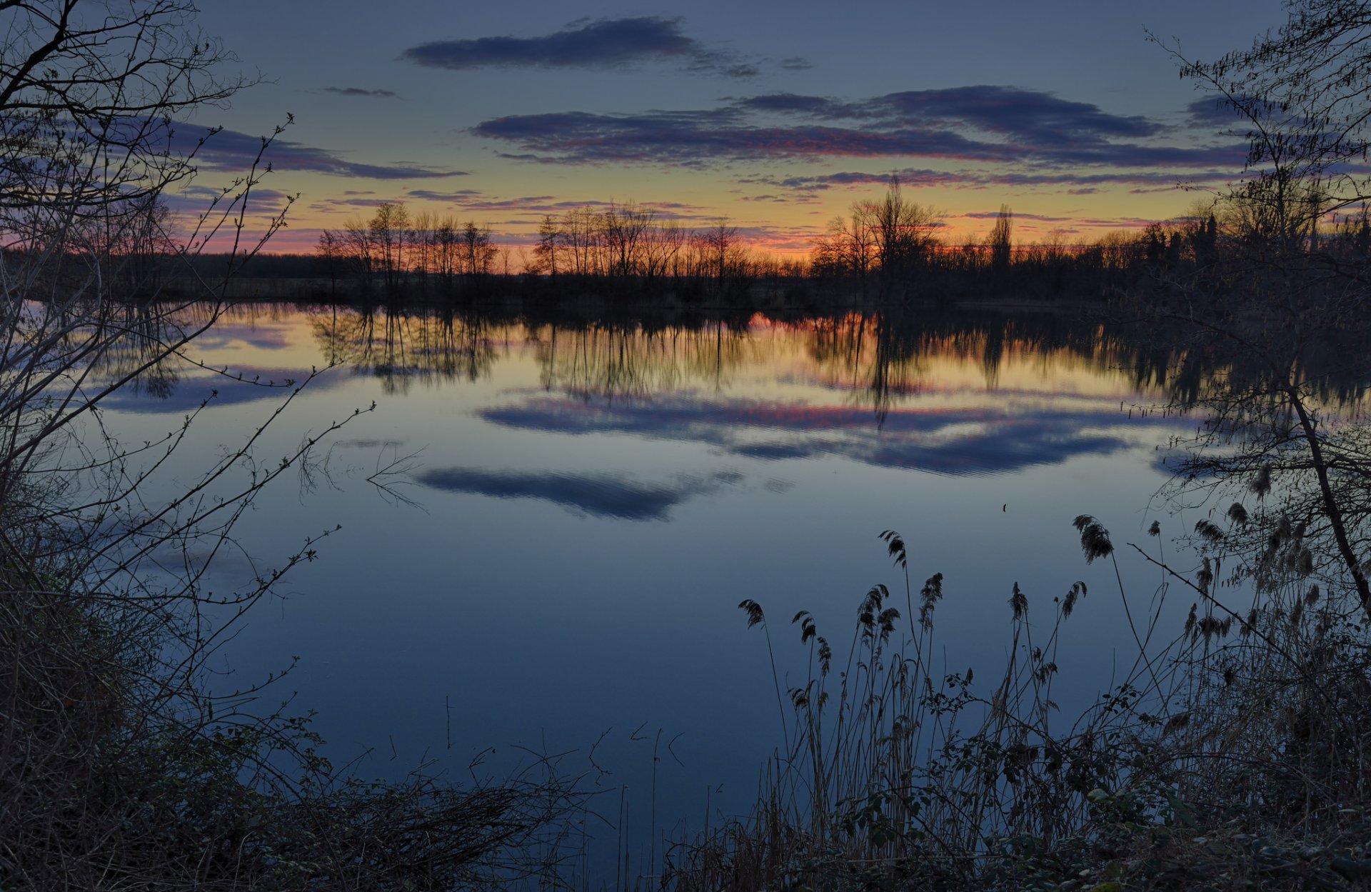 tarde invierno puesta de sol río agua orilla hierba árboles cielo nubes reflexión