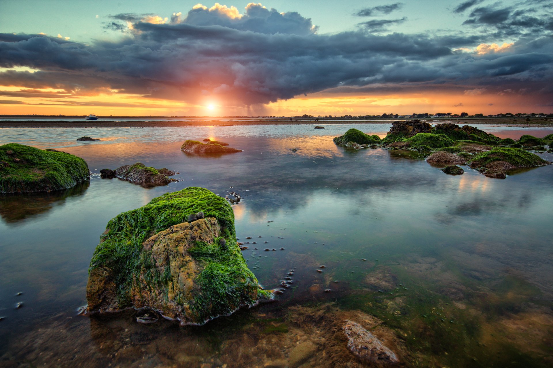 bahía rocas algas nubes lluvia puesta de sol