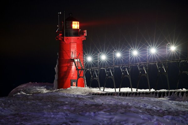 Faro nocturno entre la nieve en invierno