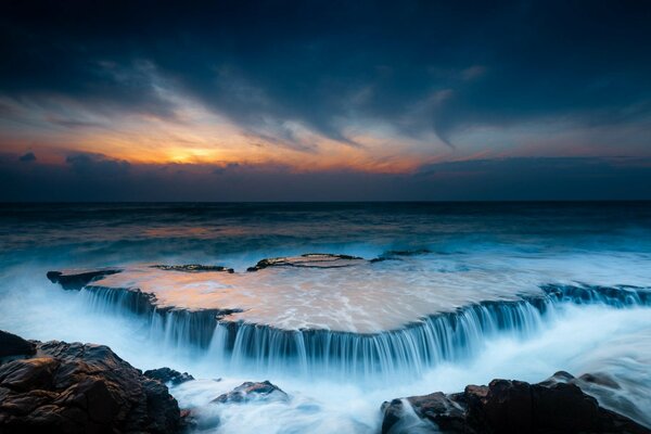 Rocky shore and waterfalls at dawn