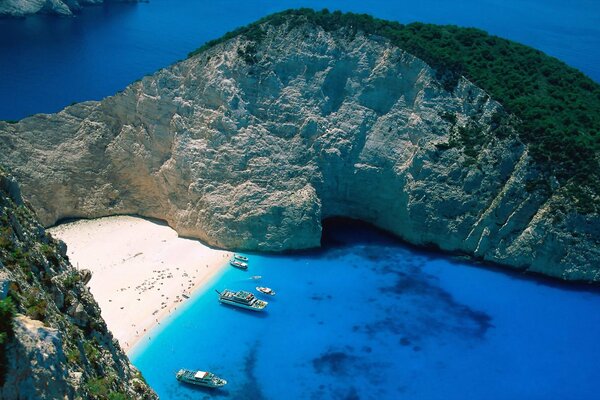 Beach with boats and rocks with greenery