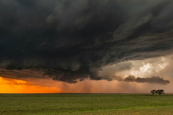 Black clouds in the sky over the field