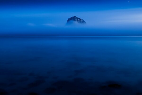 Marinero roca en la niebla de la noche