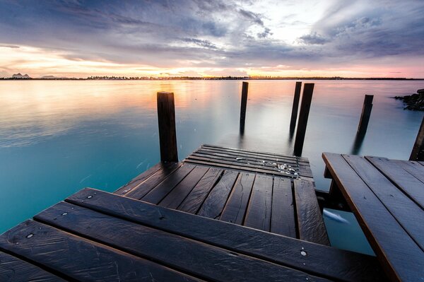 Muelle de madera en el río al atardecer