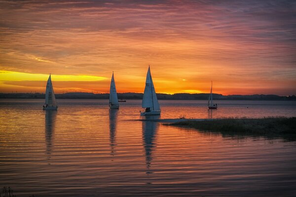 Segelboote bei Sonnenuntergang am See