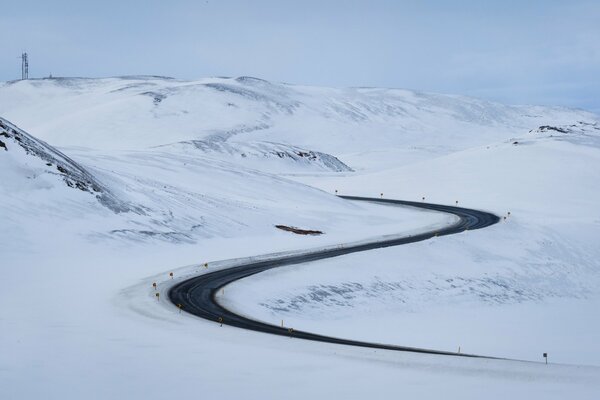 A road in the snow with a clear blue sky