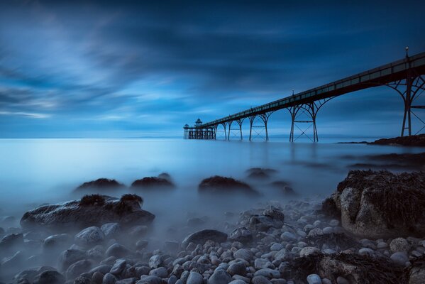 Muelle en Dal contra el mar brumoso y el cielo azul