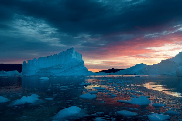 Snow-capped mountains ice floes sunset leaden clouds