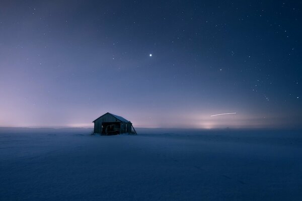 A lonely house stands in a snowy field