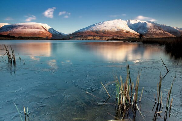 Lago limpio entre montañas nevadas