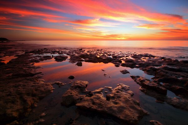 Playa de piedra. El amanecer se refleja en el mar. Hermoso paisaje