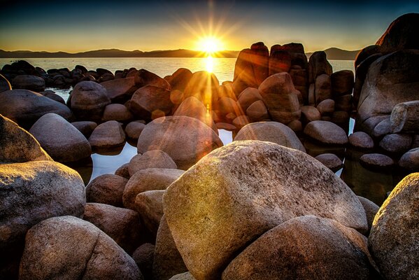 El sol de la puesta de sol se asoma entre las rocas de la bahía