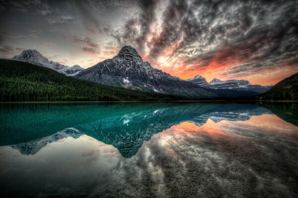 Reflejo de la puesta de sol y las montañas en el lago