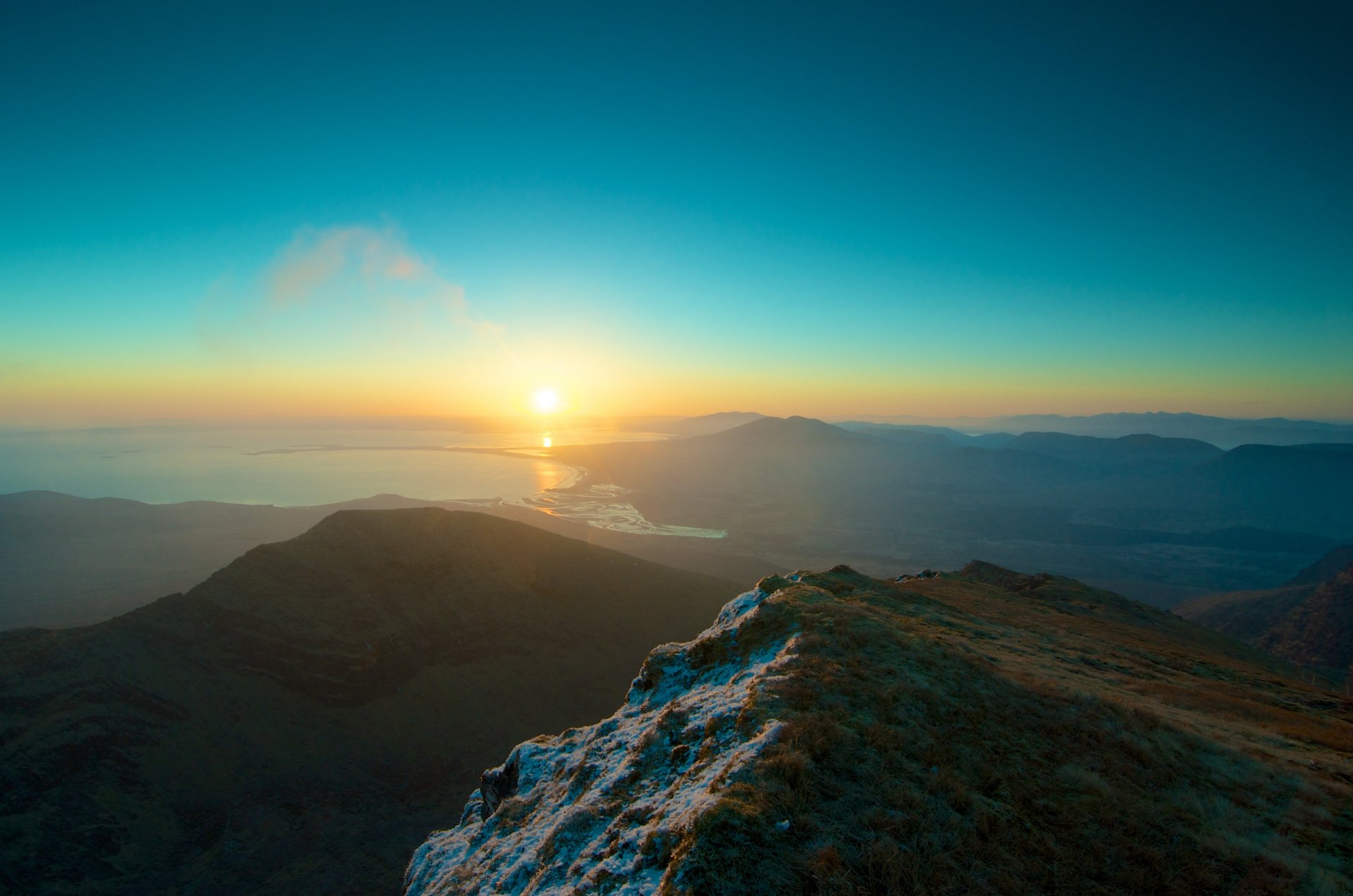 ocean water mountain snow grass sky sun sunset horizon