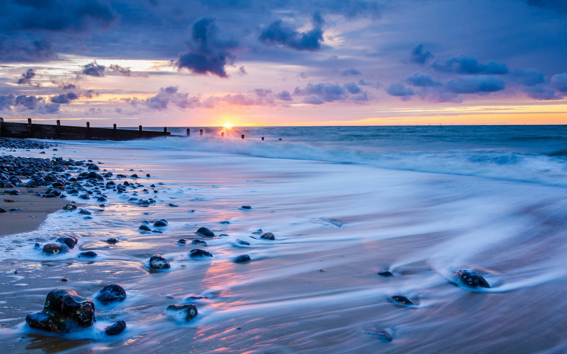 reino unido inglaterra norfolk mar costa rocas surf tarde puesta de sol sol horizonte cielo nubes nubes