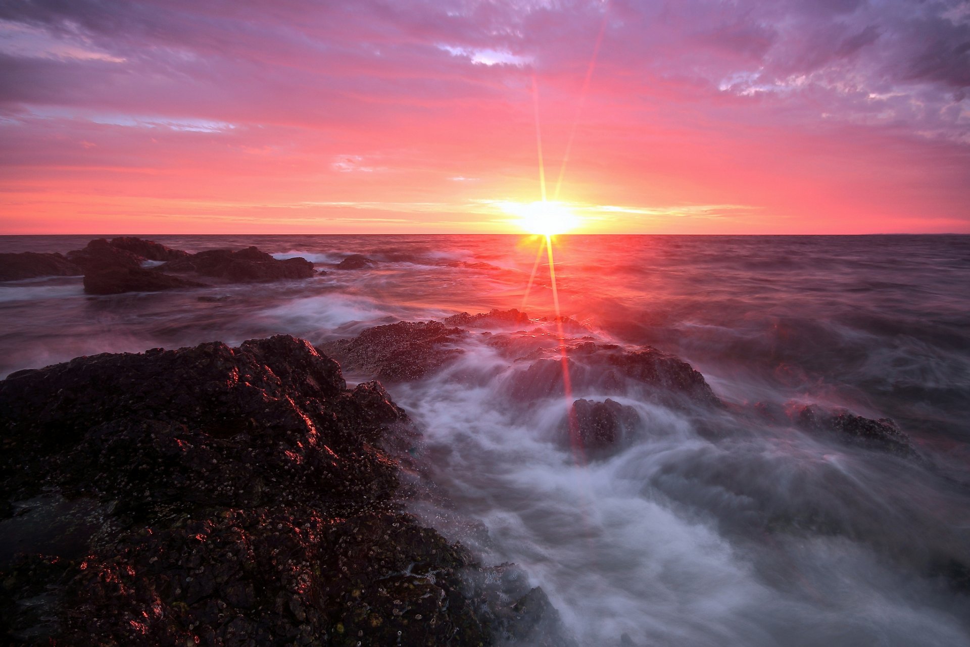 mare pietre sole raggi nuvole mattina