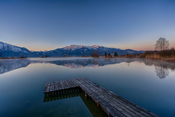 Morgendämmerung am See mit Blick auf die Berge