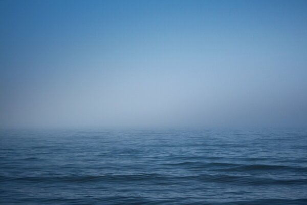 Niebla blanca sobre el mar azul