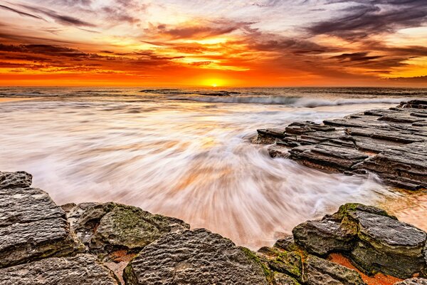 Spiaggia rocciosa sullo sfondo del tramonto