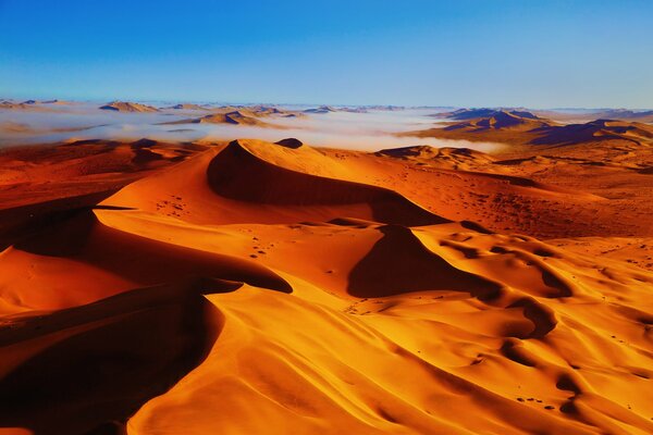 Bright orange dunes against a blue sky