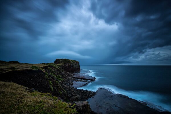 Il fait sombre. Côte rocheuse et mer