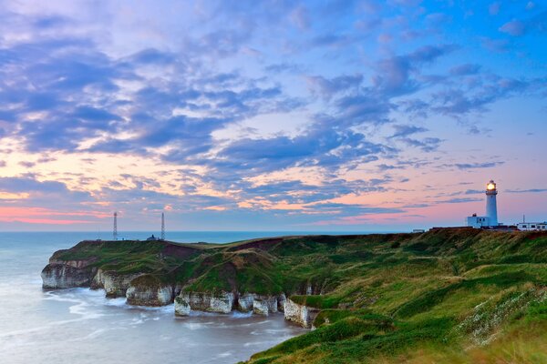 The seashore with a lighthouse at dawn