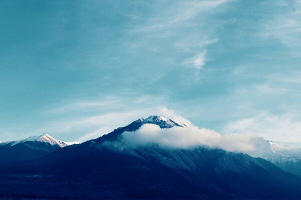 Sommets enneigés des montagnes dans les nuages